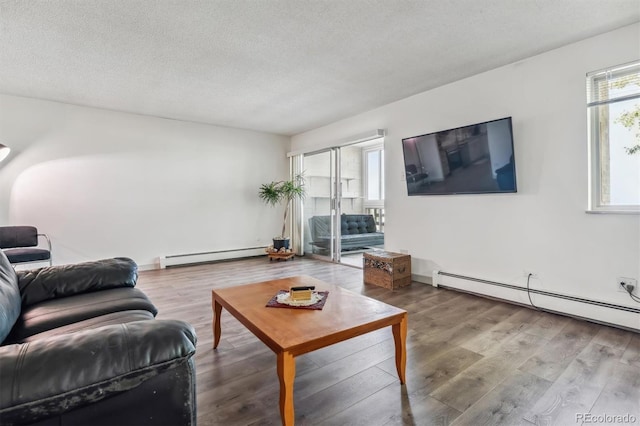 living room featuring hardwood / wood-style flooring, a baseboard radiator, plenty of natural light, and a textured ceiling