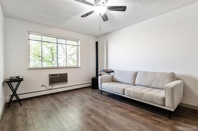 sitting room with wood-type flooring, a textured ceiling, a baseboard radiator, and a wall mounted AC