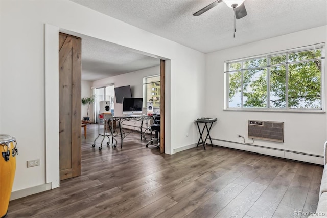 unfurnished room featuring dark wood-type flooring, a textured ceiling, baseboard heating, a wall unit AC, and ceiling fan