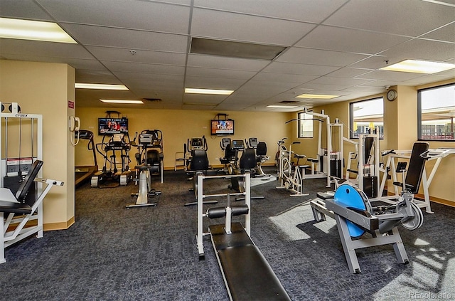 workout area with dark carpet and a paneled ceiling