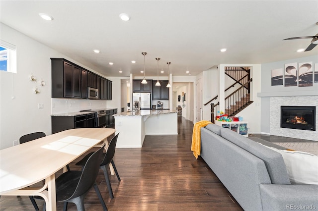 19316 W 84th Pl, Arvada, CO 80007 - living area with dark wood finished floors, stairs, recessed lighting, a glass covered fireplace, and ceiling fan