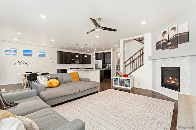 19316 W 84th Pl, Arvada, CO 80007 - living room featuring dark wood-style flooring, recessed lighting, ceiling fan, a glass covered fireplace, and stairway