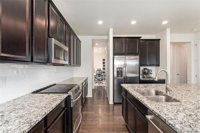 19316 W 84th Pl, Arvada, CO 80007 - kitchen with stainless steel appliances, a sink, light stone countertops, dark wood-style flooring, and backsplash