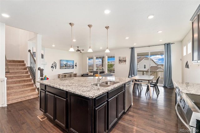 19316 W 84th Pl, Arvada, CO 80007 - kitchen with stainless steel appliances, dark wood finished floors, recessed lighting, a sink, and light stone countertops