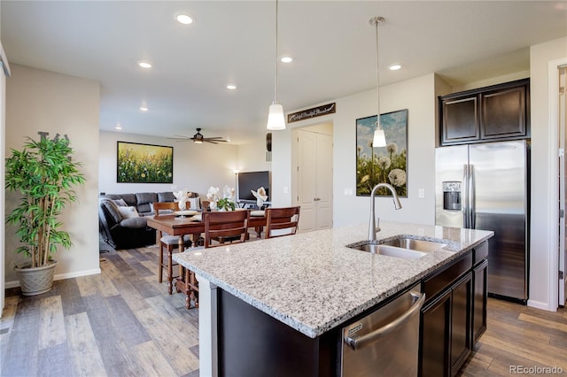 kitchen with hardwood / wood-style floors, sink, hanging light fixtures, and appliances with stainless steel finishes