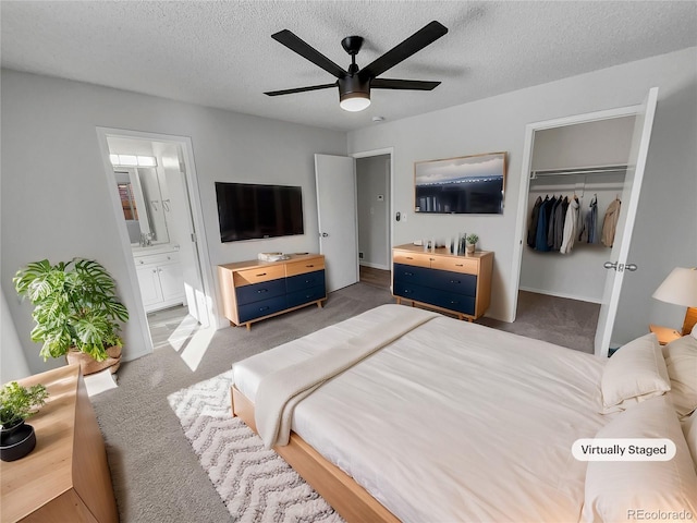 bedroom featuring ceiling fan, carpet, connected bathroom, a closet, and a textured ceiling