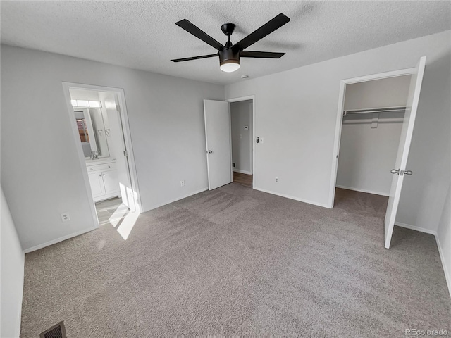 unfurnished bedroom with light carpet, ceiling fan, a textured ceiling, and a closet