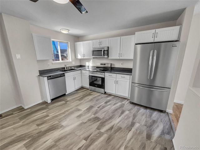 kitchen featuring appliances with stainless steel finishes, light hardwood / wood-style floors, white cabinetry, and sink