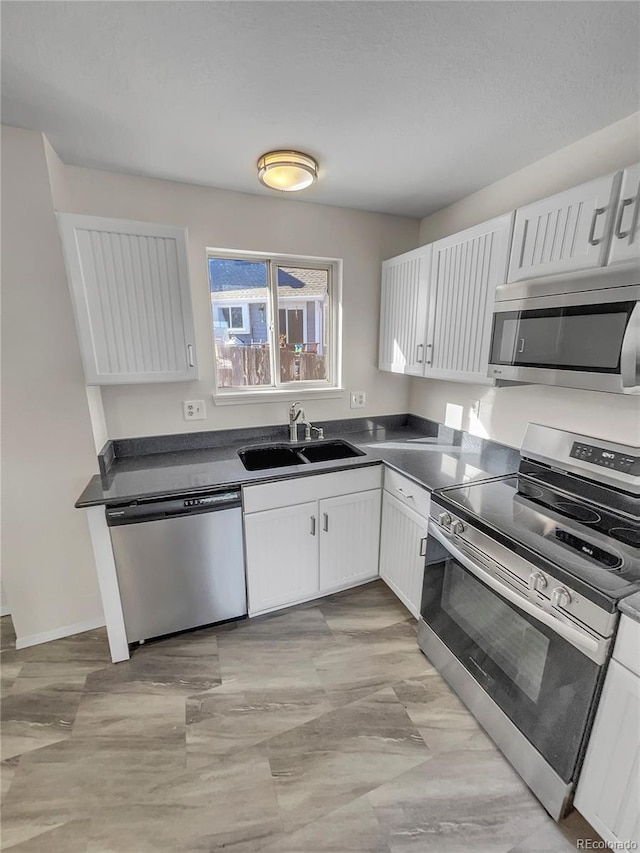 kitchen featuring stainless steel appliances, white cabinets, and sink