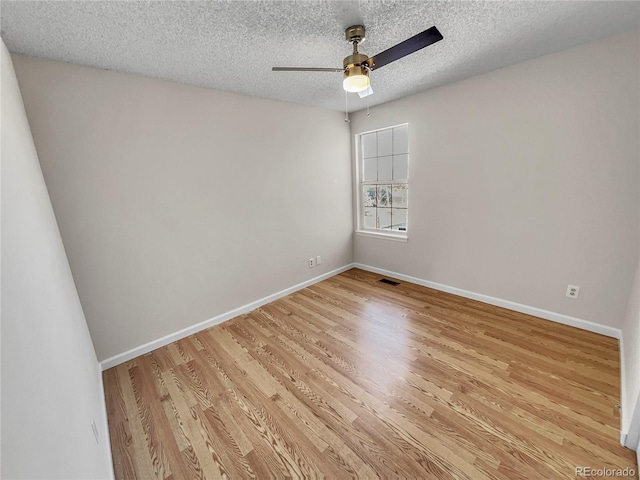 empty room featuring light wood-type flooring, ceiling fan, and a textured ceiling