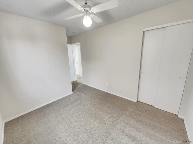 unfurnished bedroom with ceiling fan, a closet, carpet floors, and a textured ceiling