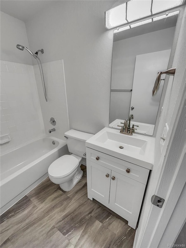 full bathroom featuring toilet, vanity, wood-type flooring, and bathing tub / shower combination