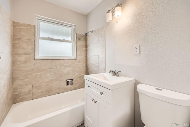 bathroom with toilet, bathtub / shower combination, vanity, and a textured wall