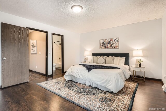 bedroom featuring baseboards, a textured ceiling, wood finished floors, and ensuite bathroom