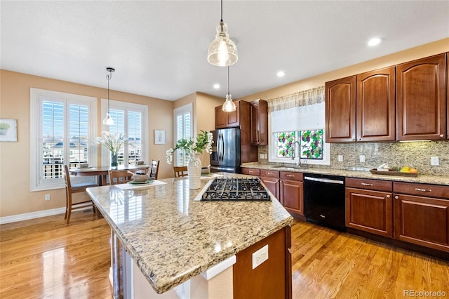 kitchen featuring hanging light fixtures, sink, stainless steel appliances, and a center island