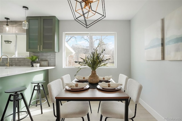 dining space featuring a chandelier, light hardwood / wood-style floors, and sink