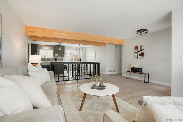 living room featuring beam ceiling and hardwood / wood-style flooring