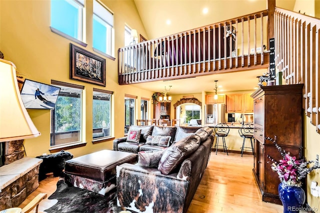 2891 Nugget Rd, Fairplay, CO 80440 - living room with healthy amount of natural light, light wood-style floors, a high ceiling, and a chandelier