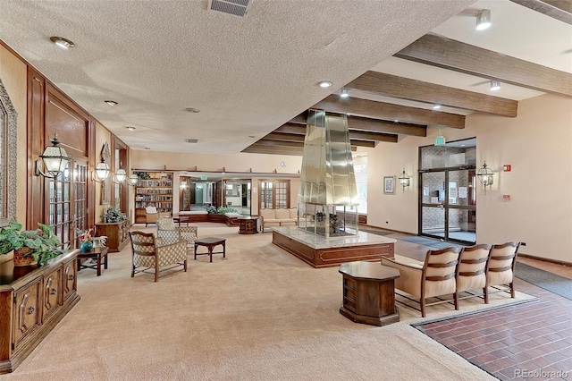 carpeted living room with beamed ceiling and a textured ceiling