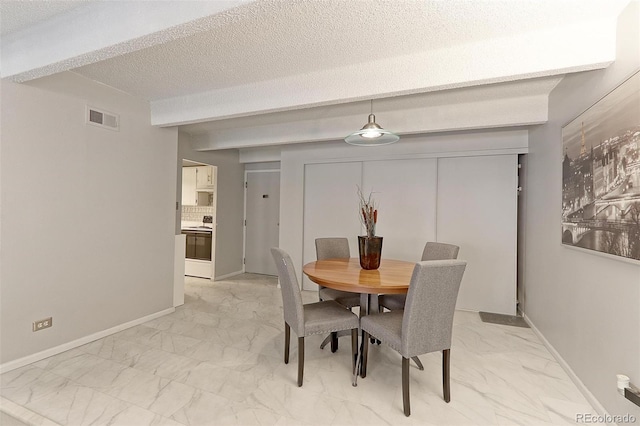 tiled dining area with a textured ceiling