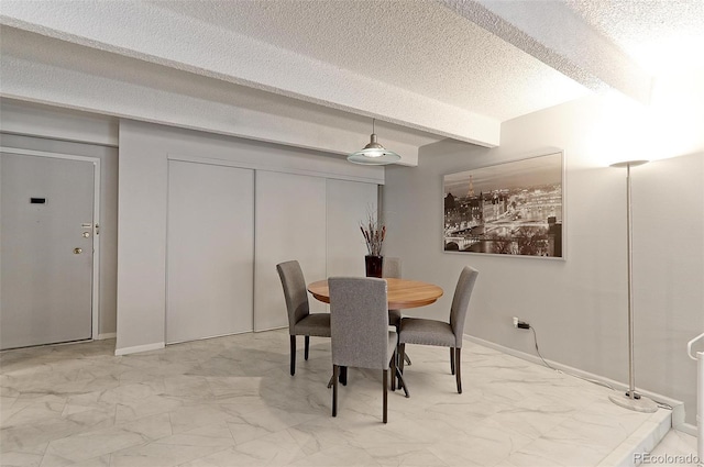 dining area featuring a textured ceiling, tile patterned flooring, and beamed ceiling