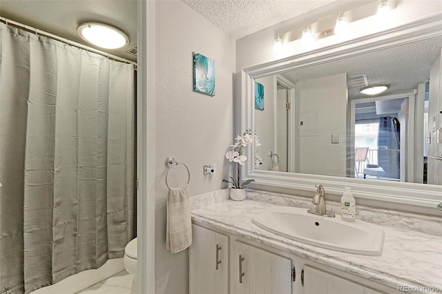 bathroom featuring a textured ceiling, toilet, and vanity