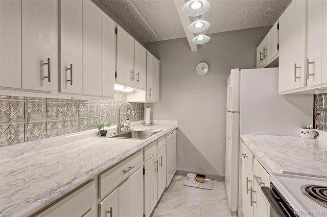 kitchen featuring sink, backsplash, white cabinetry, and light tile patterned flooring