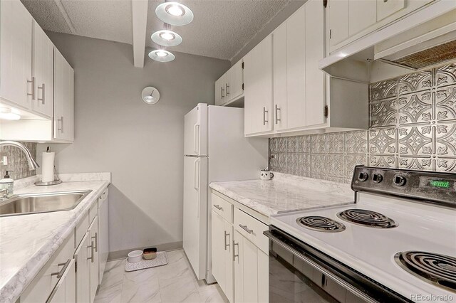 kitchen featuring decorative backsplash, white cabinets, range, and sink