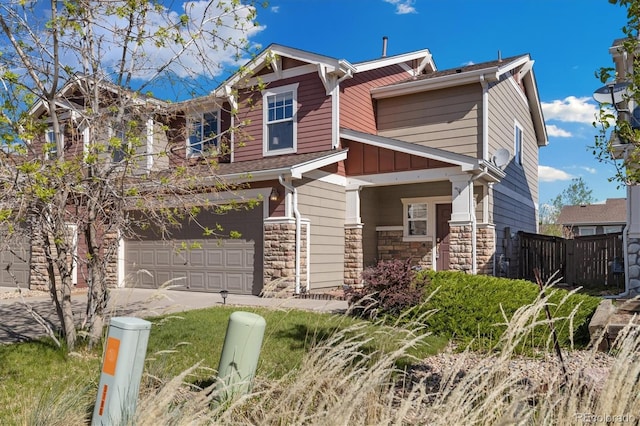craftsman-style home featuring fence, stone siding, a garage, and driveway