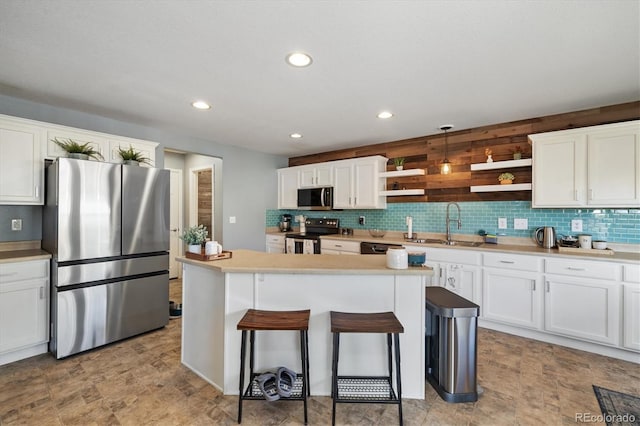 kitchen with stainless steel appliances, open shelves, white cabinetry, a sink, and recessed lighting