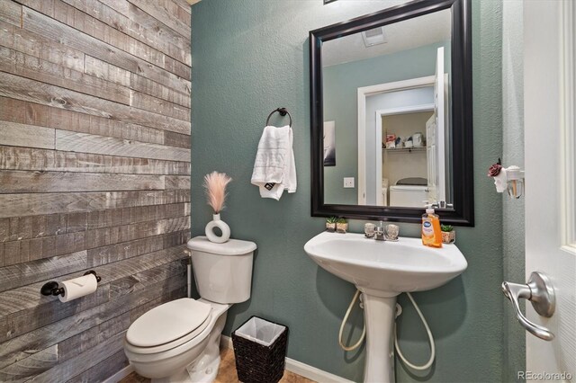 bathroom featuring toilet, baseboards, and a sink