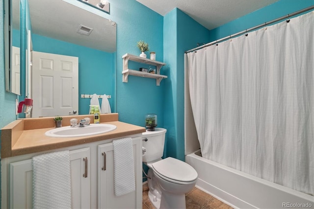 bathroom with toilet, vanity, shower / tub combo with curtain, tile patterned flooring, and a textured ceiling