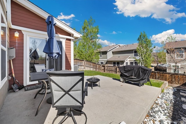 view of patio / terrace featuring an outdoor fire pit, a fenced backyard, a grill, and a residential view