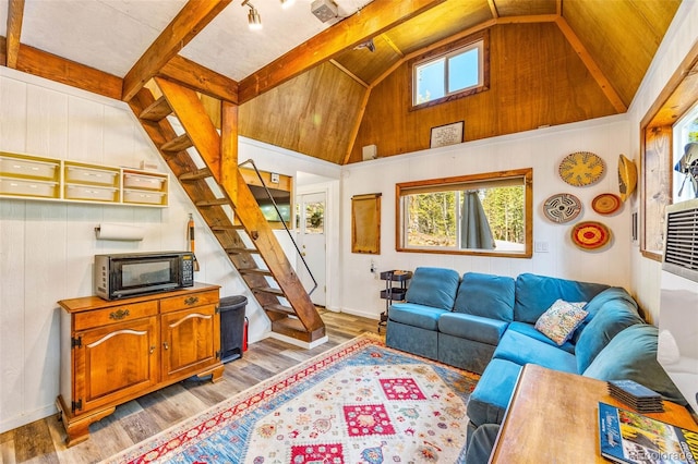 495 Georgia Pass, Jefferson, CO 80456 - living room featuring plenty of natural light, stairs, light wood finished floors, beam ceiling, and high vaulted ceiling