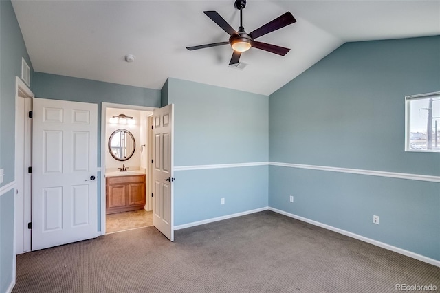 unfurnished bedroom featuring lofted ceiling, carpet flooring, sink, ceiling fan, and ensuite bath