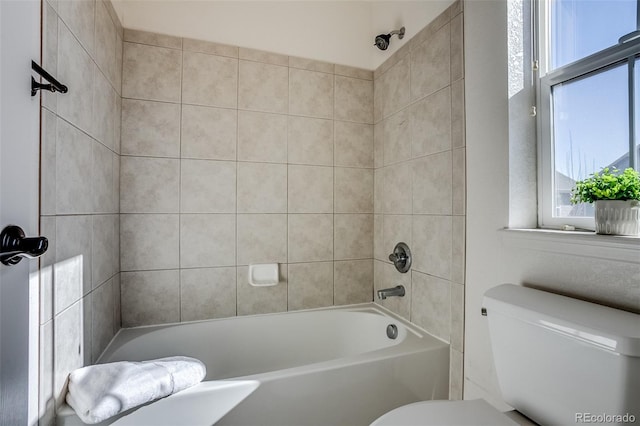 bathroom with tiled shower / bath and toilet