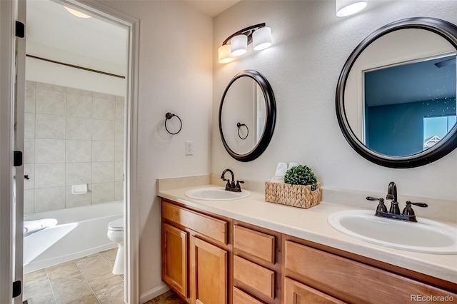 full bathroom featuring vanity, tiled shower / bath combo, and toilet