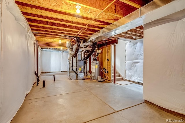 basement featuring gas water heater and heating unit