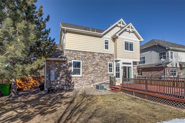 rear view of property with a wooden deck, a yard, and central air condition unit