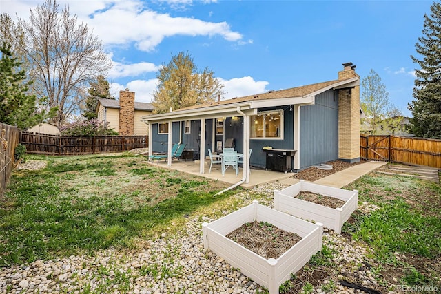 7005 Zenobia Pl, Westminster, CO 80030 - rear view of house featuring a patio, a fenced backyard, a vegetable garden, a chimney, and a yard