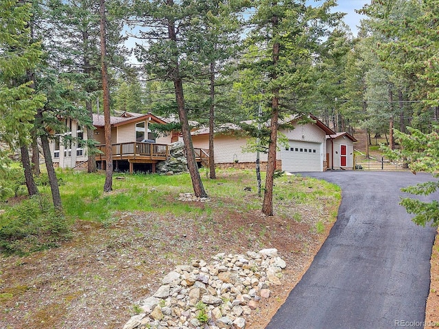 7585 Native Dancer Trl, Evergreen, CO 80439 - view of front of house featuring driveway, a wooden deck, and a garage