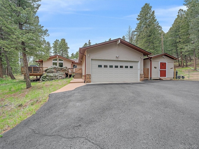 7585 Native Dancer Trl, Evergreen, CO 80439 - view of front of property featuring a garage, driveway, and a deck