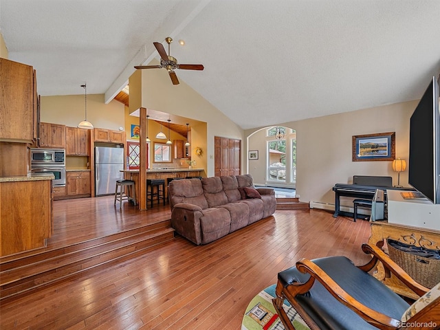 7585 Native Dancer Trl, Evergreen, CO 80439 - living room featuring beamed ceiling, hardwood / wood-style flooring, ceiling fan, and high vaulted ceiling