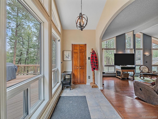 7585 Native Dancer Trl, Evergreen, CO 80439 - entryway with lofted ceiling, a chandelier, baseboards, and arched walkways