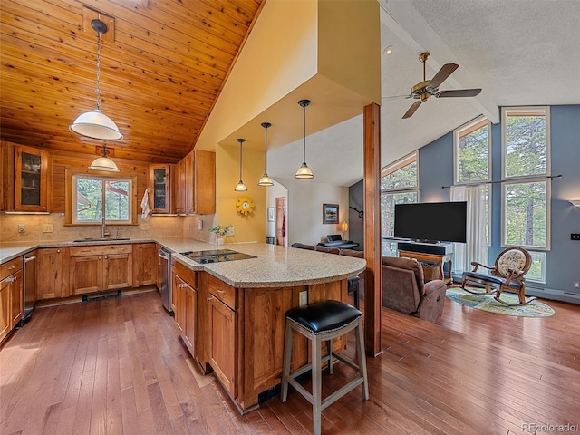 7585 Native Dancer Trl, Evergreen, CO 80439 - kitchen featuring brown cabinetry, stainless steel dishwasher, open floor plan, a peninsula, and beam ceiling
