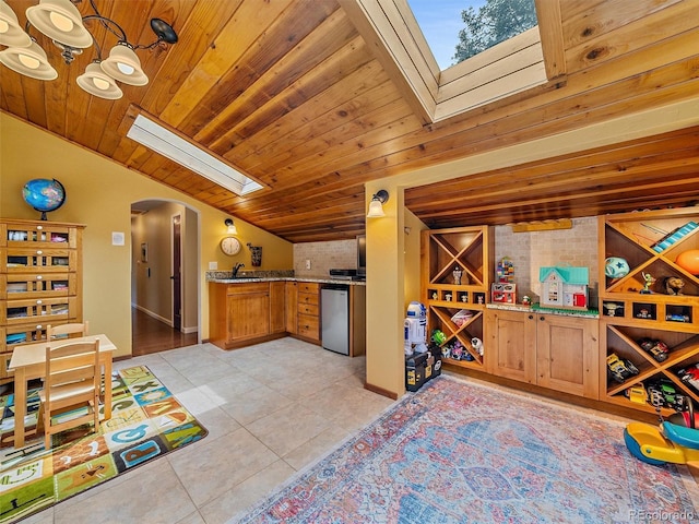 7585 Native Dancer Trl, Evergreen, CO 80439 - kitchen featuring fridge, arched walkways, a skylight, light tile patterned floors, and vaulted ceiling