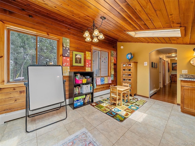 7585 Native Dancer Trl, Evergreen, CO 80439 - dining room featuring arched walkways, wooden ceiling, plenty of natural light, light tile patterned floors, and wood walls