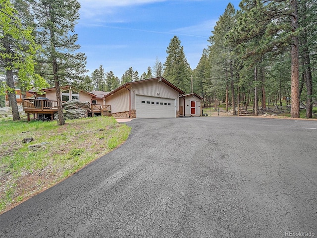 7585 Native Dancer Trl, Evergreen, CO 80439 - view of front facade with a garage, driveway, and a deck
