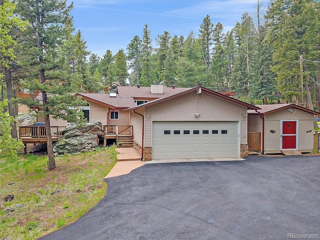 7585 Native Dancer Trl, Evergreen, CO 80439 - view of front of home featuring an attached garage, asphalt driveway, and a deck