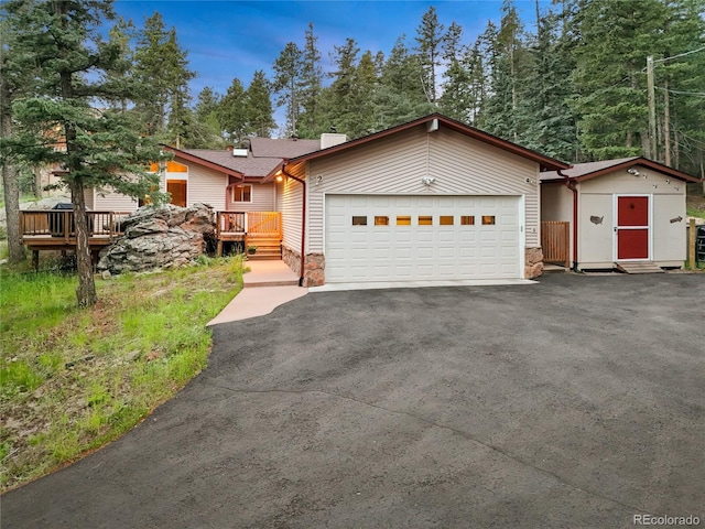 7585 Native Dancer Trl, Evergreen, CO 80439 - view of front of house with a garage, driveway, a shed, and a wooden deck